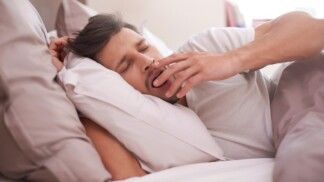 Homem boceja durante sono da cama
