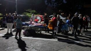 Pessoas permanecem ao lado de pacientes em cadeiras de rodas e camas hospitalares na rua, do lado de fora de um hospital, após um terremoto em Caracas, na Venezuela, em 24/06/2026