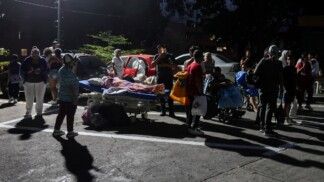 Pessoas permanecem ao lado de pacientes em cadeiras de rodas e camas hospitalares na rua, do lado de fora de um hospital, após um terremoto em Caracas, na Venezuela, em 24/06/2026