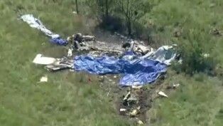 Destroços de um avião estão espalhados em um campo ao lado do Aeroporto Memorial de Butler após a queda de uma aeronave que transportava paraquedistas, em Butler, no estado do Missouri, Estados Unidos, em 14/06/2026.