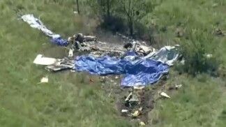 Destroços de um avião estão espalhados em um campo ao lado do Aeroporto Memorial de Butler após a queda de uma aeronave que transportava paraquedistas, em Butler, no estado do Missouri, Estados Unidos, em 14/06/2026.