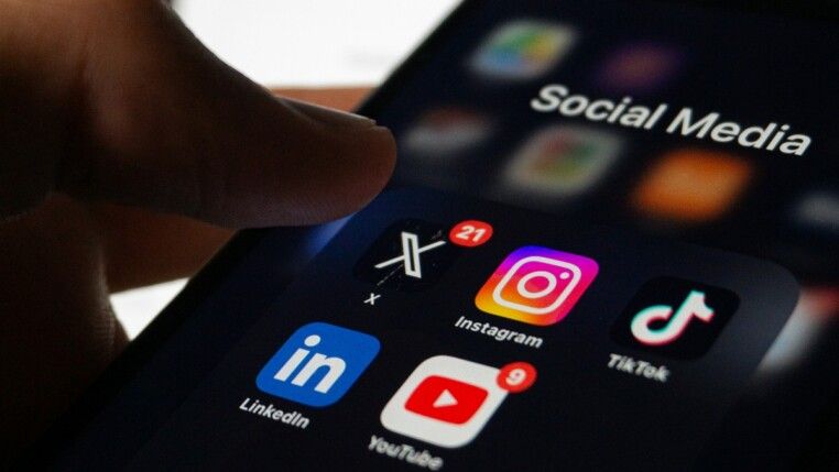 Celular com tela preta e ícones do X, Instagram, TikTok, LinkedIn e YouTube