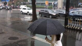 Com guarda-chuvas, pedestres se protegem do frio e da garoa na Avenida Paulista, na região central de São Paulo,