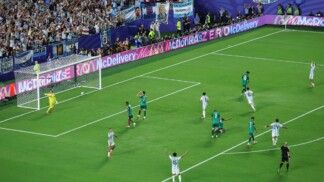 O argentino Lionel Messi comemora seu terceiro gol na vitória sobre a Argélia, superando o goleiro Luca Zidane e completando seu primeiro hat-trick em Copas do Mundo