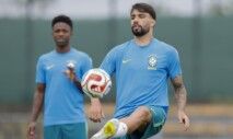 Paquetá peteca a bola e, atrás dele, Vini Jr. observa, durante treino da Seleção
