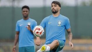 Paquetá peteca a bola e, atrás dele, Vini Jr. observa, durante treino da Seleção