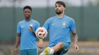 Paquetá peteca a bola e, atrás dele, Vini Jr. observa, durante treino da Seleção