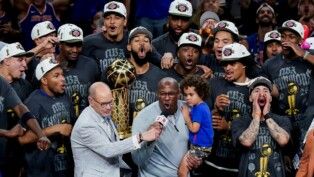 O técnico do New York Knicks, Mike Brown, comemora após a vitória sobre o San Antonio Spurs no Jogo 5 das Finais da NBA de 2026, no Frost Bank Center, resultado que garantiu o título da NBA de 2026 para a franquia nova-iorquina.
