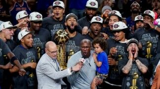 O técnico do New York Knicks, Mike Brown, comemora após a vitória sobre o San Antonio Spurs no Jogo 5 das Finais da NBA de 2026, no Frost Bank Center, resultado que garantiu o título da NBA de 2026 para a franquia nova-iorquina.