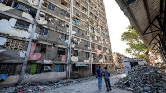 Moradores observam um prédio danificado em Catia La Mar, no estado de La Guaira, Venezuela, em 29/06/2026. As esperanças de encontrar sobreviventes diminuíam mais de quatro dias após os fortes terremotos que atingiram o país, enquanto aumentava a frustração da população com a resposta do governo ao desastre, que deixou ao menos 1.450 mortos e dezenas de milhares de desaparecidos.