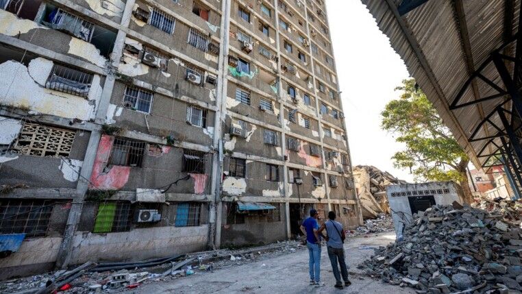 Moradores observam um prédio danificado em Catia La Mar, no estado de La Guaira, Venezuela, em 29/06/2026. As esperanças de encontrar sobreviventes diminuíam mais de quatro dias após os fortes terremotos que atingiram o país, enquanto aumentava a frustração da população com a resposta do governo ao desastre, que deixou ao menos 1.450 mortos e dezenas de milhares de desaparecidos.