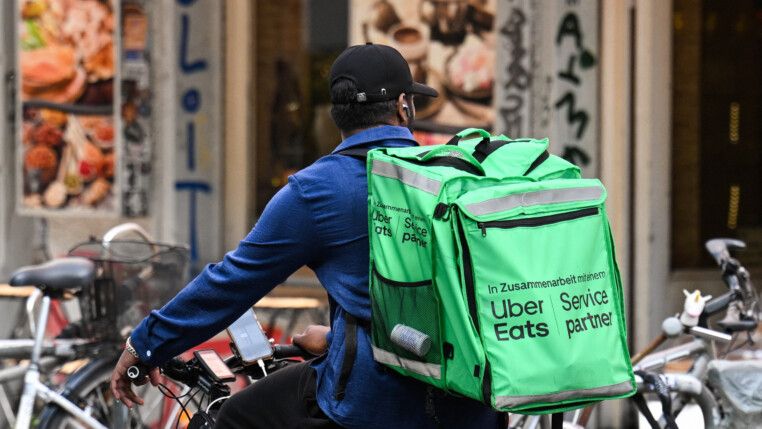Um entregador de comida de bicicleta, carregando uma mochila da Uber Eats, pedala em Berlim, Alemanha, em 16 de julho de 2026