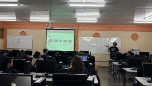 Sala com varias mesas e computadores