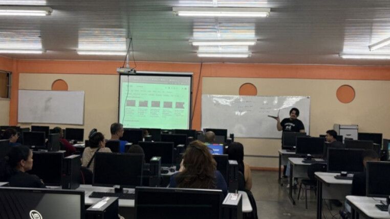 Sala com varias mesas e computadores