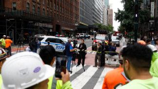 Members of the media work near a building on 42nd Street, which was reported to have structural issues, in New York City, U.S., July 7, 2026. REUTERS/Jordan Tovin