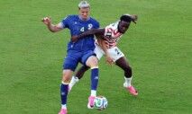 Balogun, dos EUA, comete falta sobre Tarik Muharemovic, da Bósnia e Herzegovina, antes de receber cartão vermelho.
