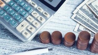 calculadora, moedas e notas de dólares