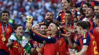 Futebol — Copa do Mundo da FIFA 2026 — final — Espanha x Argentina — Estádio de Nova York/Nova Jersey, East Rutherford, Nova Jersey, EUA — 19/07/2026. Álex Grimaldo ergue o troféu da Copa do Mundo ao lado dos companheiros de seleção durante a comemoração do título da Espanha.