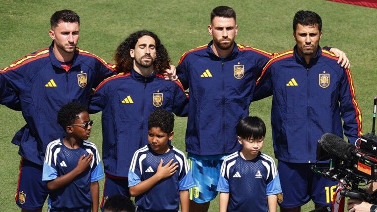 Futebol — Copa do Mundo da FIFA 2026 — final — Espanha x Argentina — Estádio de Nova York/Nova Jersey, East Rutherford, Nova Jersey, EUA — 19/07/2026. Rodri e jogadores da seleção da Espanha entram em campo ao lado de crianças durante a execução dos hinos nacionais, antes da partida.