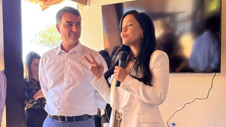 A vereadora Priscilla Costa discursa observada por Flávio Bolsonaro