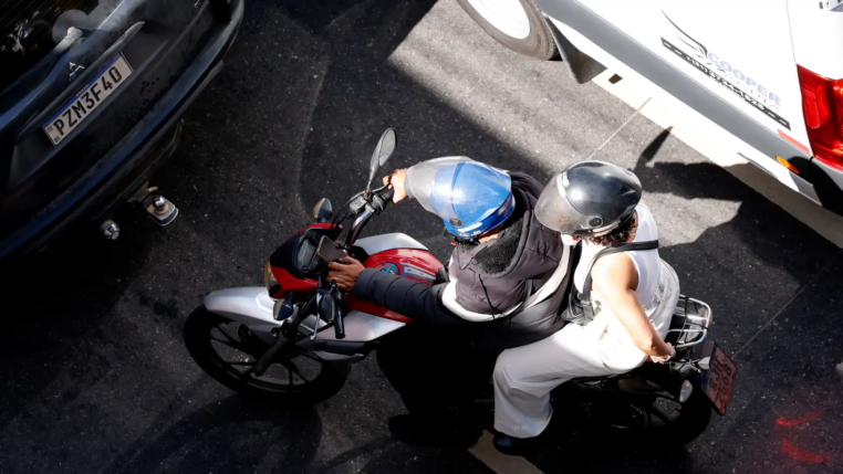 foto mostra condutor e passageira em motocicleta