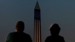 O Monumento a Washington é iluminado enquanto pessoas participam da Grande Feira Americana dos Estados (The Great American State Fair), realizada no National Mall para marcar o 4 de Julho, quando os Estados Unidos celebram o 250º aniversário da independência, em Washington, D.C., EUA, em 03/07/2026.
