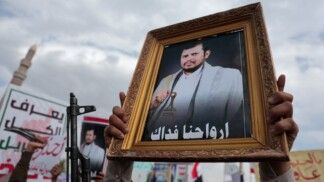 Um apoiador dos houthis ergue um retrato do líder do grupo, Abdul-Malik al-Houthi, durante um ato contra as restrições impostas pela coalizão liderada pela Arábia Saudita às áreas controladas pelos houthis, classificadas pelo grupo como um bloqueio, em Sanaa, Iêmen, em 17/07/2026.
