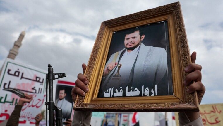 Um apoiador dos houthis ergue um retrato do líder do grupo, Abdul-Malik al-Houthi, durante um ato contra as restrições impostas pela coalizão liderada pela Arábia Saudita às áreas controladas pelos houthis, classificadas pelo grupo como um bloqueio, em Sanaa, Iêmen, em 17/07/2026.