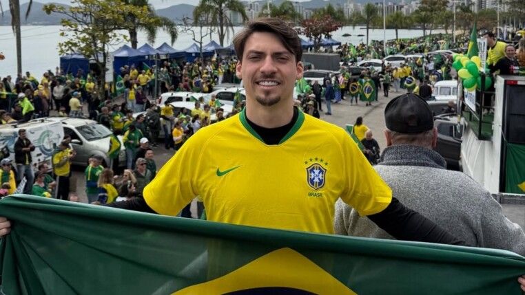 Jair Renan com a camisa da Seleção em carro elétrico, segurando a bandeira do Brasil