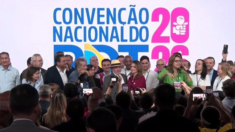 Lula ao lado de Carlos Lupi e em meio a várias pessoas no palco da covenção nacional do PDT