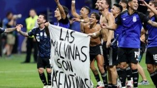Soccer Football - FIFA World Cup 2026 - Semi Final - England v Argentina - Atlanta Stadium, Atlanta, Georgia, U.S. - July 15, 2026 Argentina's Lisandro Martinez and Giovani Lo Celso celebrate with a banner after the match as Argentina qualify for the final of the World Cup REUTERS/Amanda Perobelli