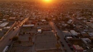 Imagem aérea mostra o campo de futebol onde Idaly Juache costumava jogar. Seus restos mortais foram encontrados dois anos após seu desaparecimento, em 2010, no Vale de Juárez. O registro foi feito em Ciudad Juárez, México, em 22/06/2026, enquanto o governo afirma que apoiar as "madres buscadoras" (mães que procuram familiares desaparecidos) é prioridade, mas parentes de desaparecidos denunciam burocracia, falta de apoio financeiro e a necessidade de realizar buscas por conta própria em áreas controladas por cartéis.