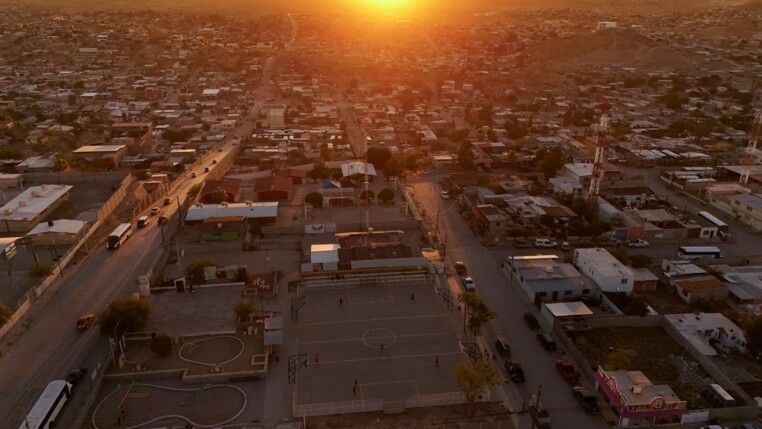 Imagem aérea mostra o campo de futebol onde Idaly Juache costumava jogar. Seus restos mortais foram encontrados dois anos após seu desaparecimento, em 2010, no Vale de Juárez. O registro foi feito em Ciudad Juárez, México, em 22/06/2026, enquanto o governo afirma que apoiar as "madres buscadoras" (mães que procuram familiares desaparecidos) é prioridade, mas parentes de desaparecidos denunciam burocracia, falta de apoio financeiro e a necessidade de realizar buscas por conta própria em áreas controladas por cartéis.